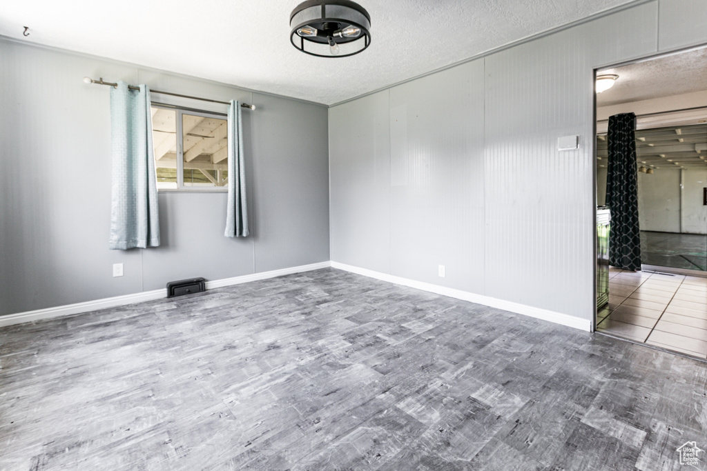 Unfurnished room with wood finished floors and a textured ceiling