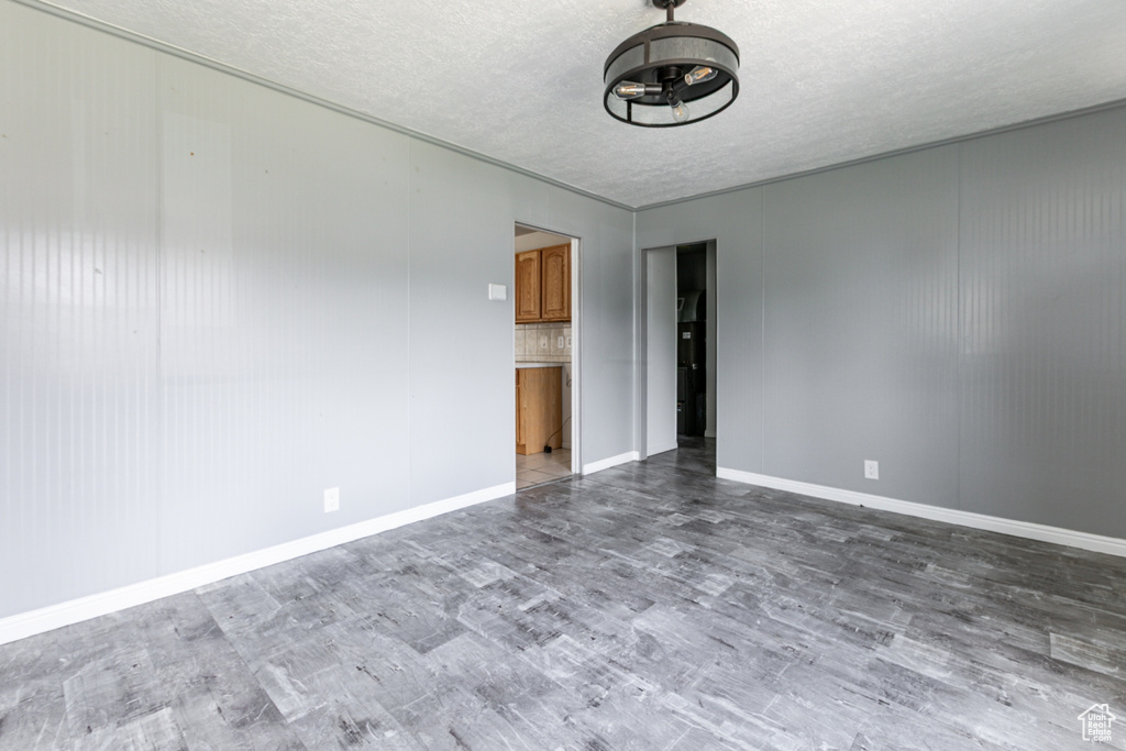 Unfurnished room featuring wood finished floors and a textured ceiling