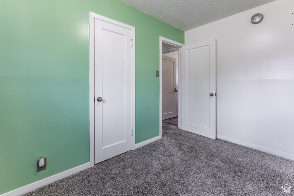 Unfurnished bedroom with carpet flooring and baseboards