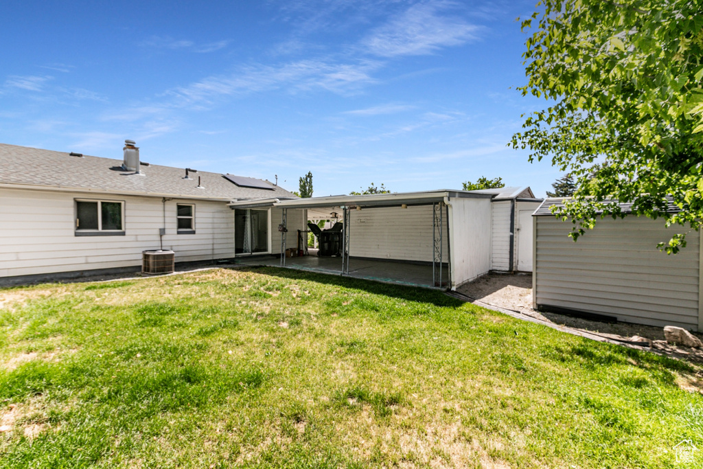 Rear view of house featuring a storage shed, a yard, and a patio