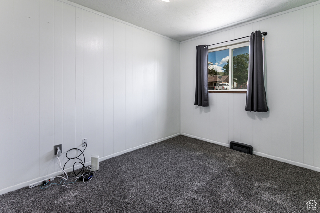 Carpeted empty room featuring a textured ceiling
