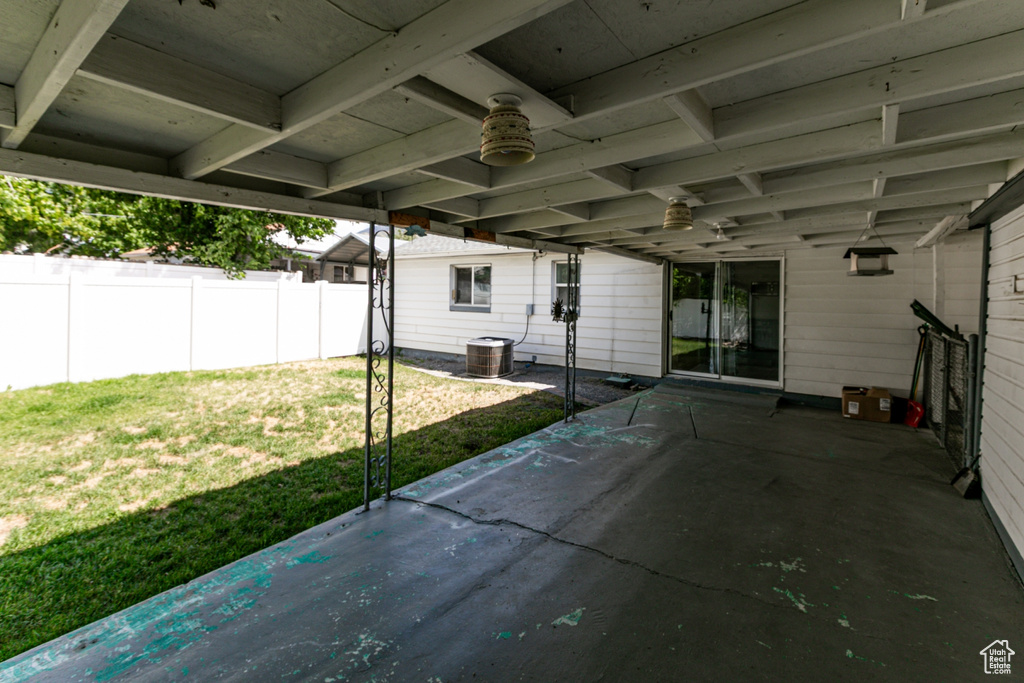 Fenced backyard featuring a patio, a ceiling fan, and a carport