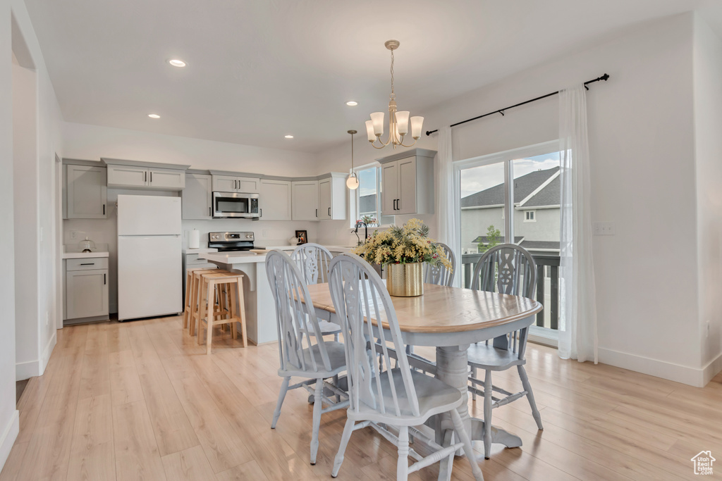 Dining room with a chandelier, light wood finished floors, and recessed lighting