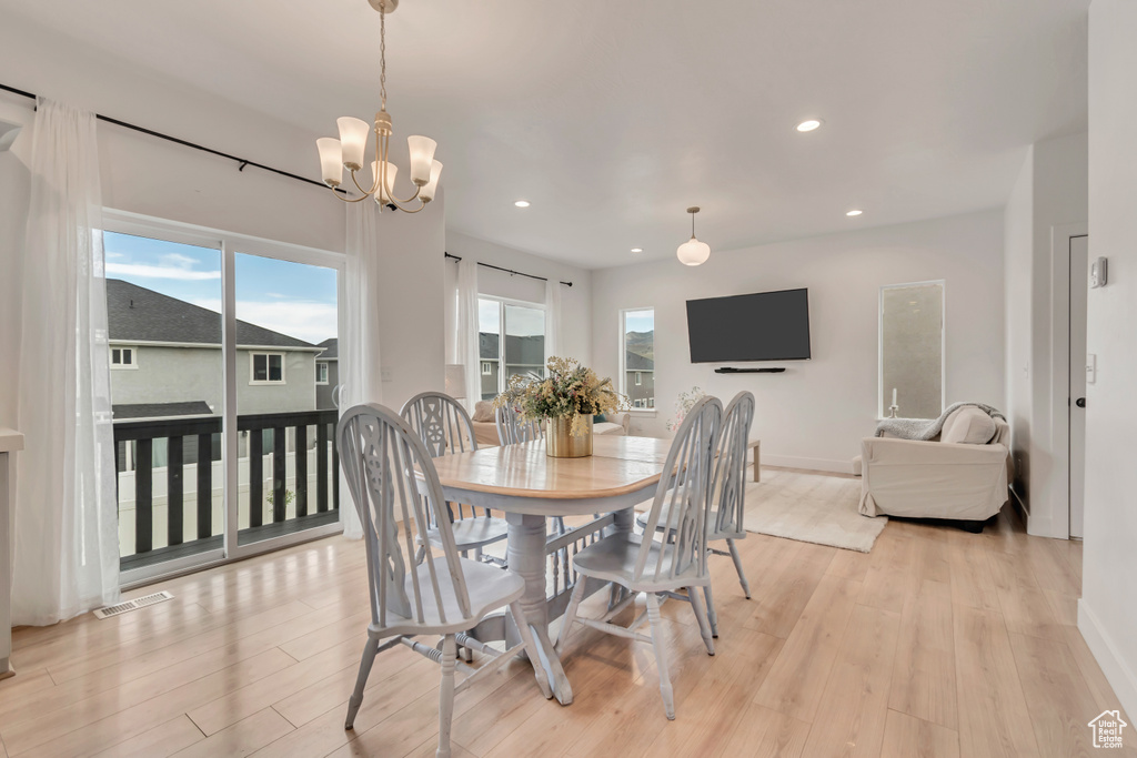 Dining space featuring light wood-type flooring, recessed lighting, and a chandelier