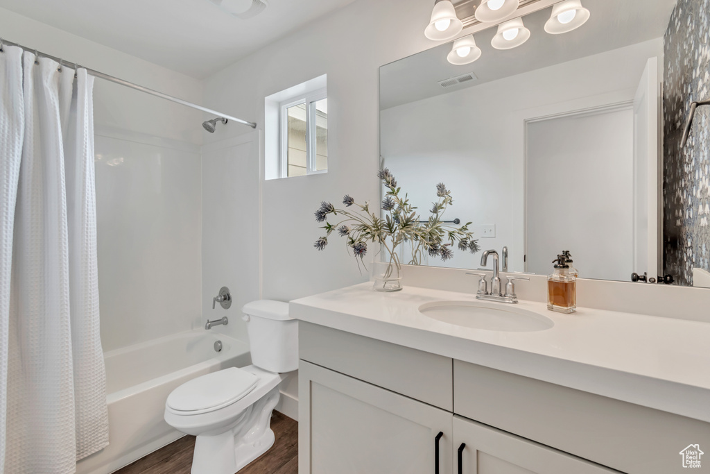 Bathroom featuring shower / bath combo, wood finished floors, and vanity