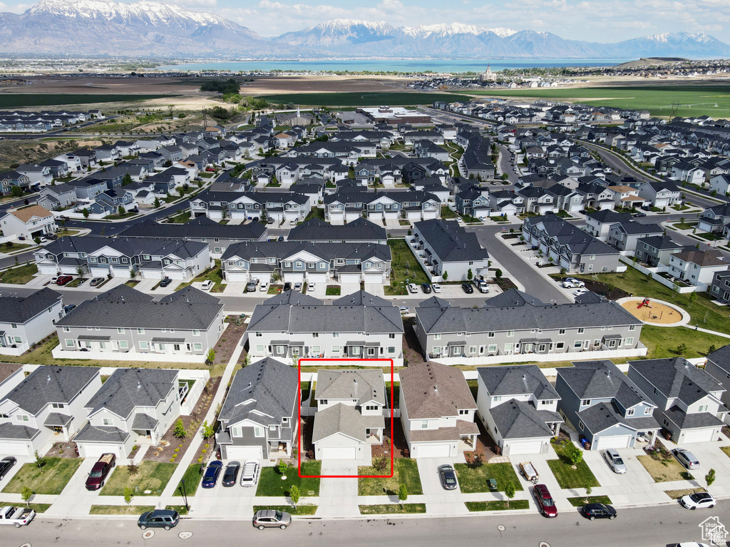 Aerial view of residential area with property parcel outlined and mountains