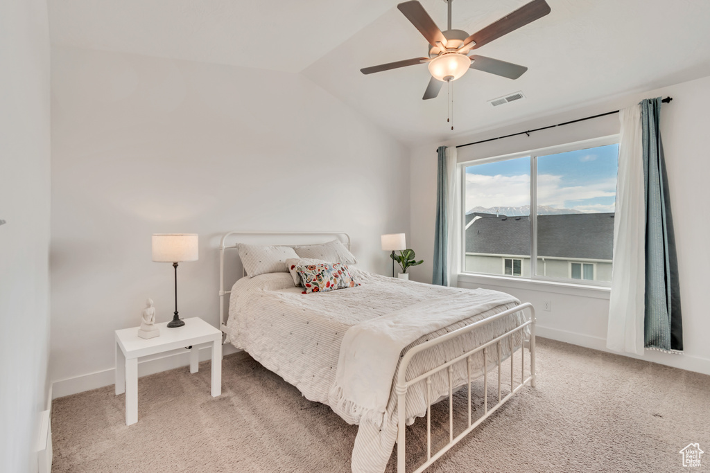 Bedroom featuring lofted ceiling, light carpet, and a ceiling fan