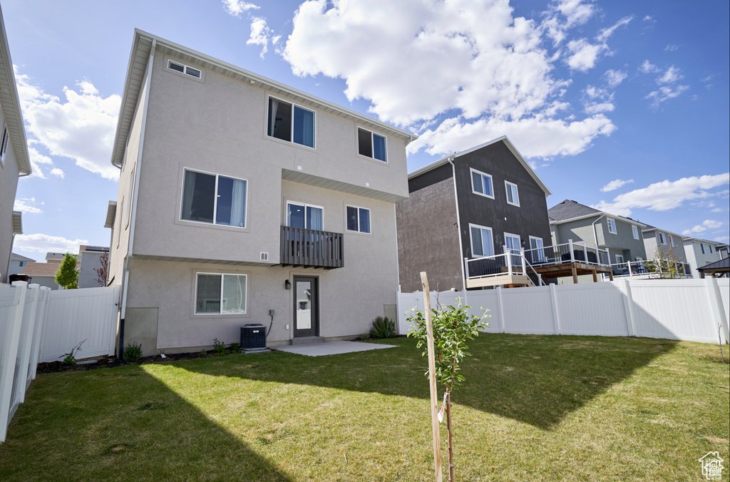Rear view of property featuring stucco siding, a fenced backyard, a balcony, and a residential view