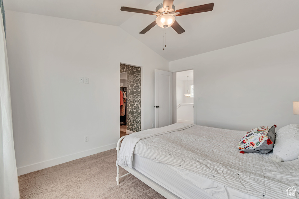 Carpeted bedroom with lofted ceiling, a spacious closet, and ceiling fan