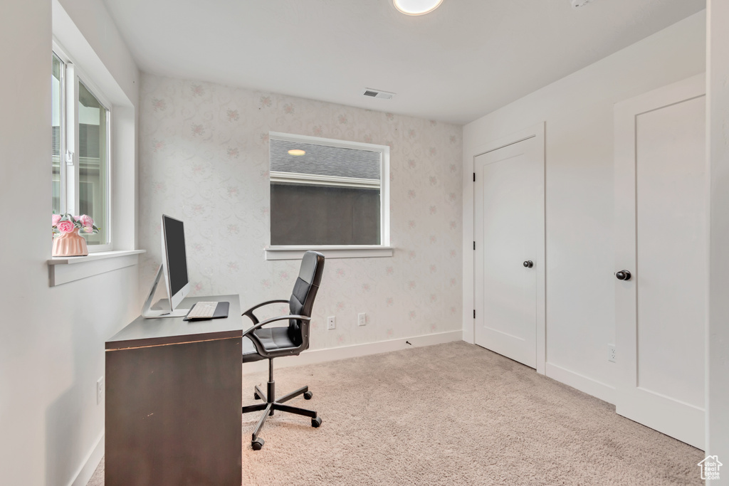 Carpeted office featuring wallpapered walls and baseboards
