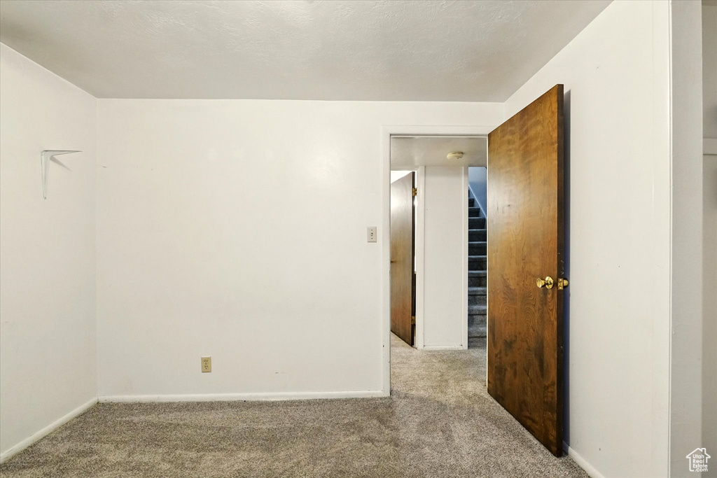 Carpeted spare room with baseboards and a smoke detector