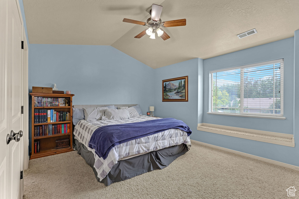 Bedroom featuring carpet floors, lofted ceiling, and ceiling fan