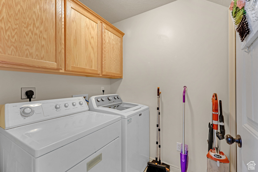 Laundry room with cabinet space and washer and clothes dryer