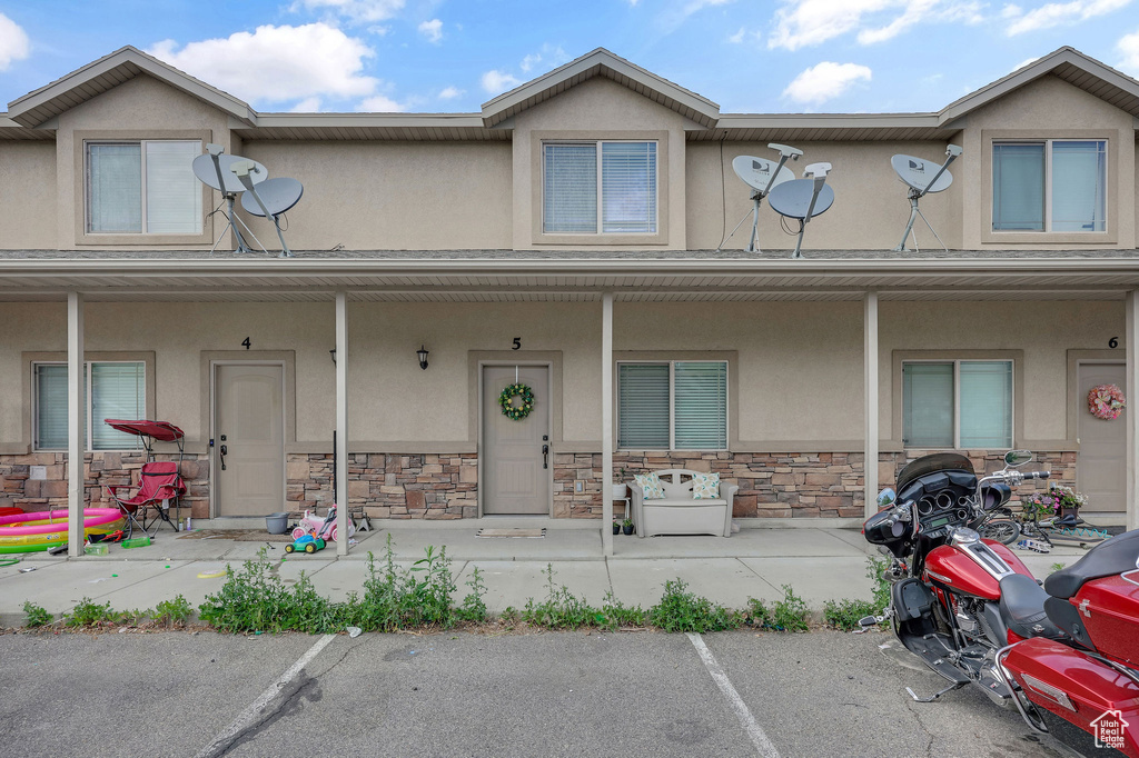 Townhome / multi-family property with stucco siding and covered porch