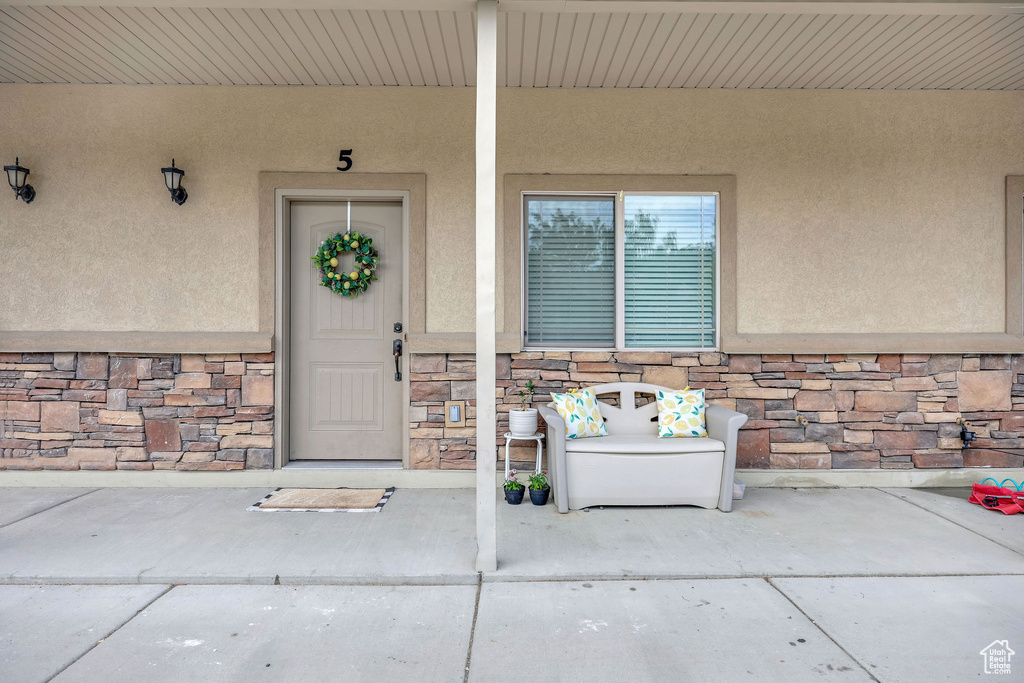 Doorway to property with stone siding and stucco siding