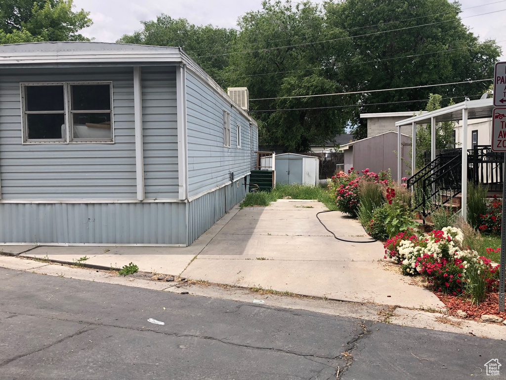 View of home's exterior featuring a shed and a patio