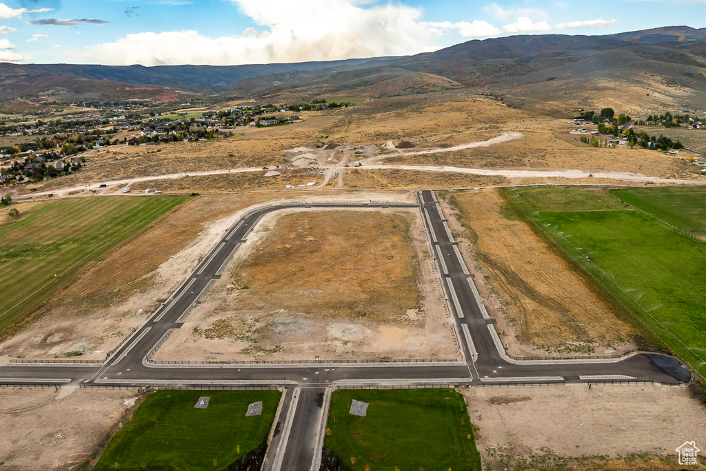 Aerial view of property and surrounding area featuring a mountain backdrop and rural landscape