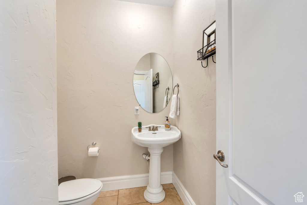 Half bath featuring tile patterned floors and toilet