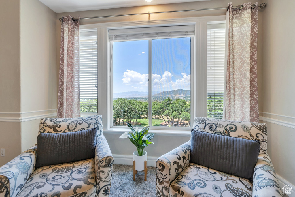 Sitting room with carpet, healthy amount of natural light, and a mountain view