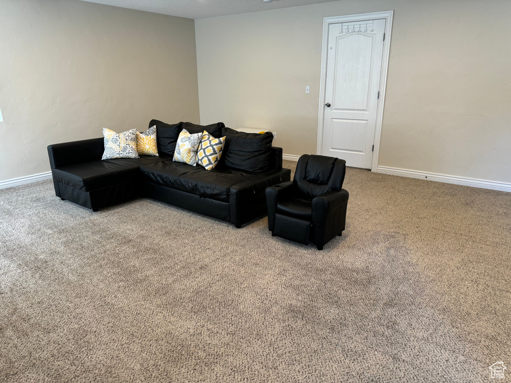 Carpeted living area featuring baseboards