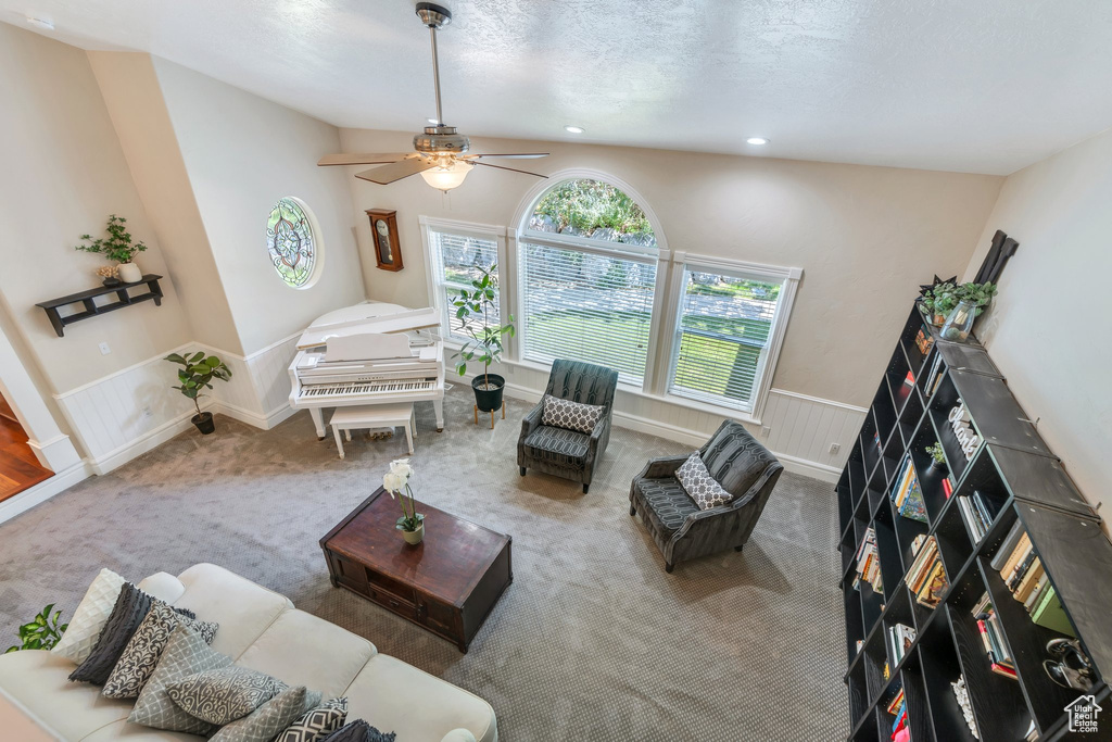 Carpeted living area featuring a ceiling fan and recessed lighting