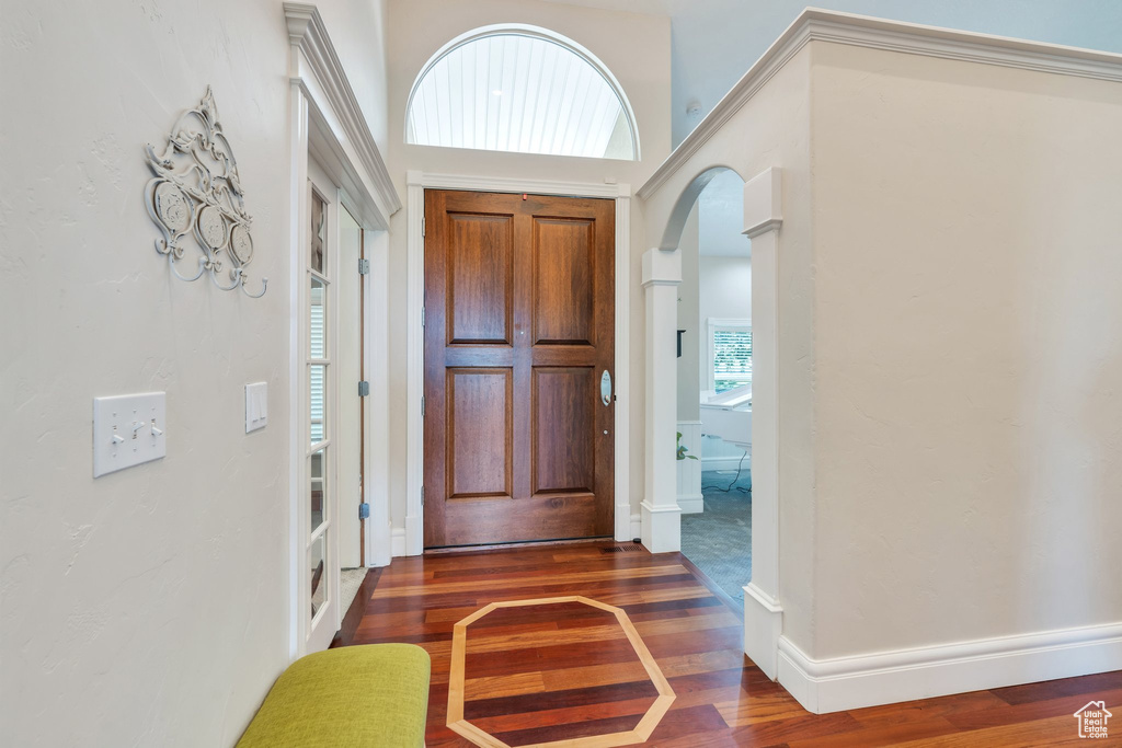 Foyer with wood finished floors and arched walkways