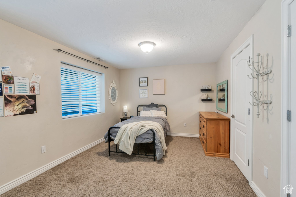 Bedroom featuring carpet flooring and a textured ceiling