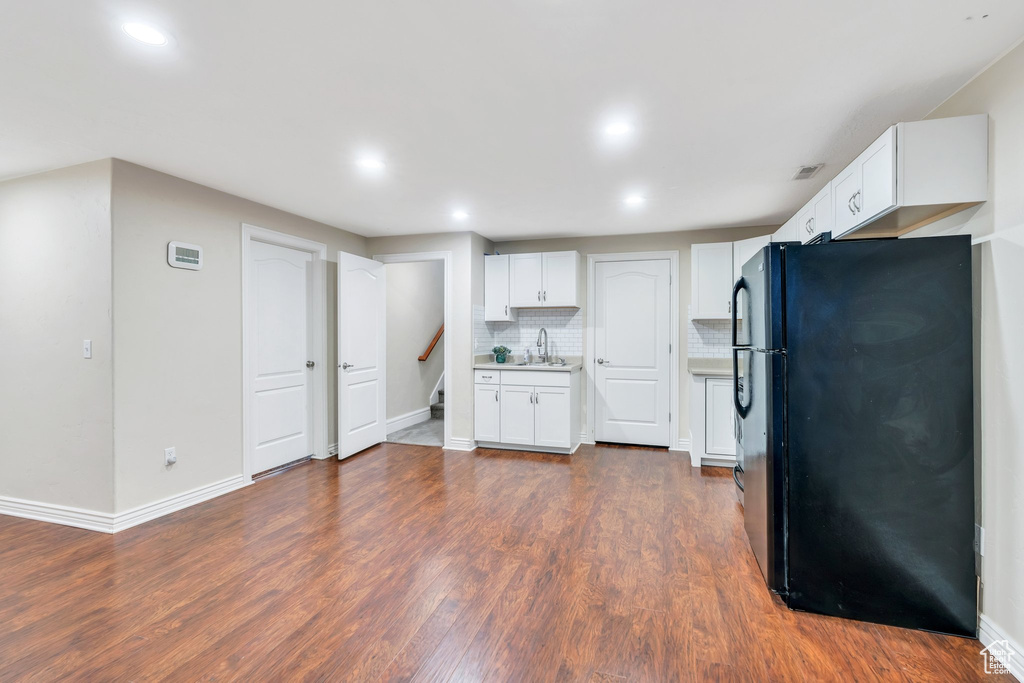 Kitchen with freestanding refrigerator, recessed lighting, white cabinets, decorative backsplash, and dark wood finished floors