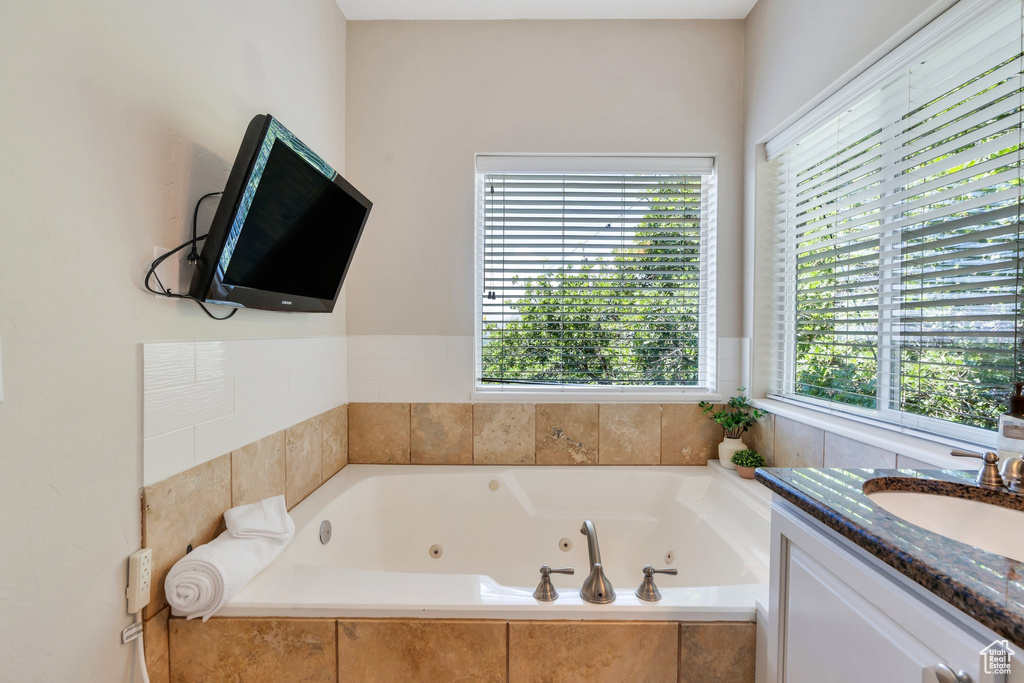 Full bathroom with a whirlpool tub and vanity