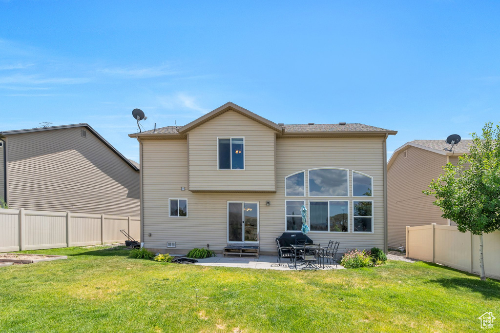 Rear view of house featuring a fenced backyard and a patio