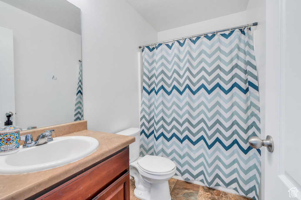 Bathroom featuring vanity, stone finish floors, and a shower with curtain