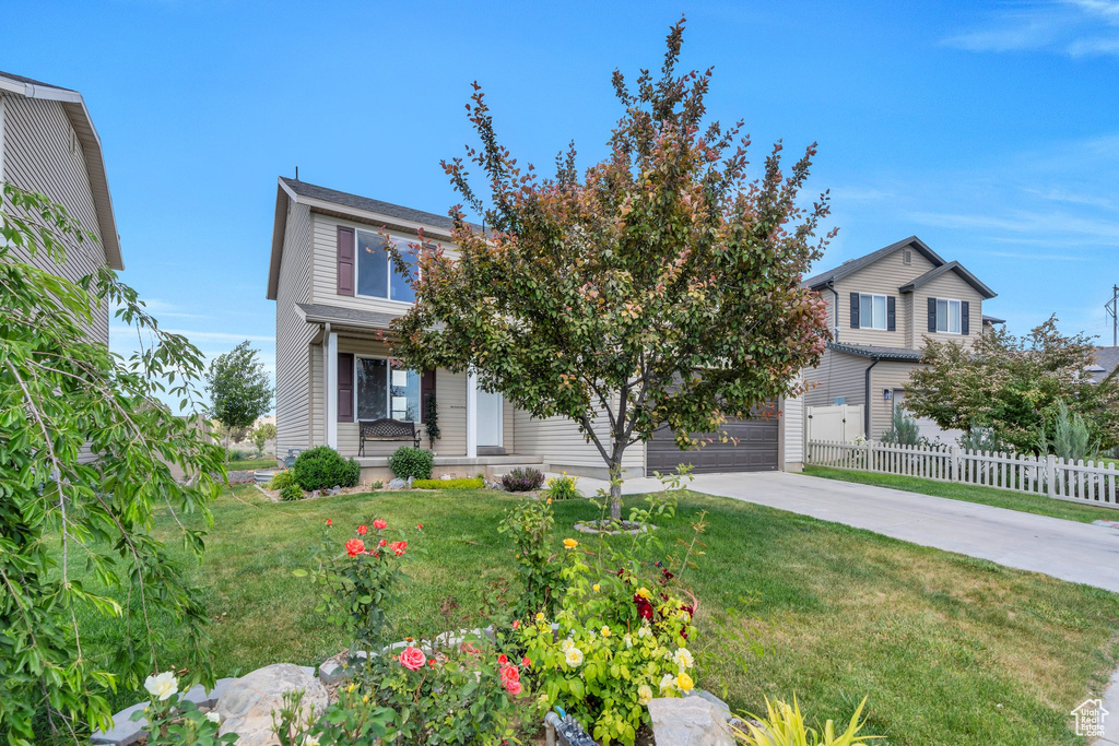 View of front facade featuring driveway and a garage