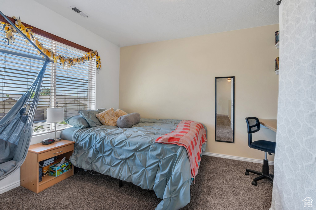 Bedroom featuring carpet and multiple windows