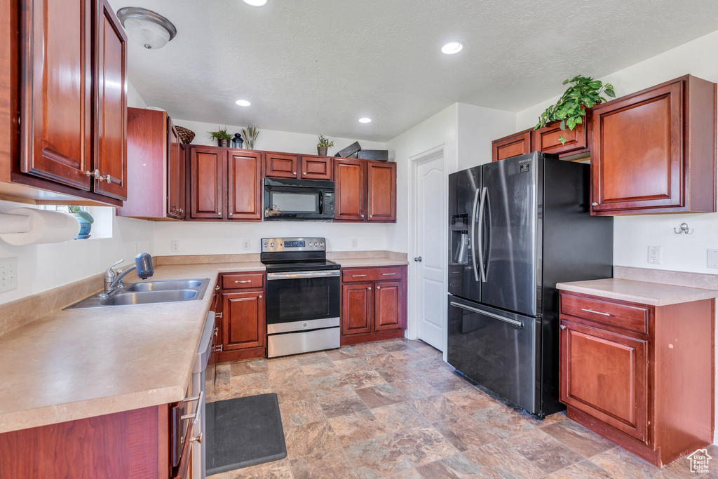 Kitchen featuring stainless steel appliances, recessed lighting, light countertops, and stone finish flooring