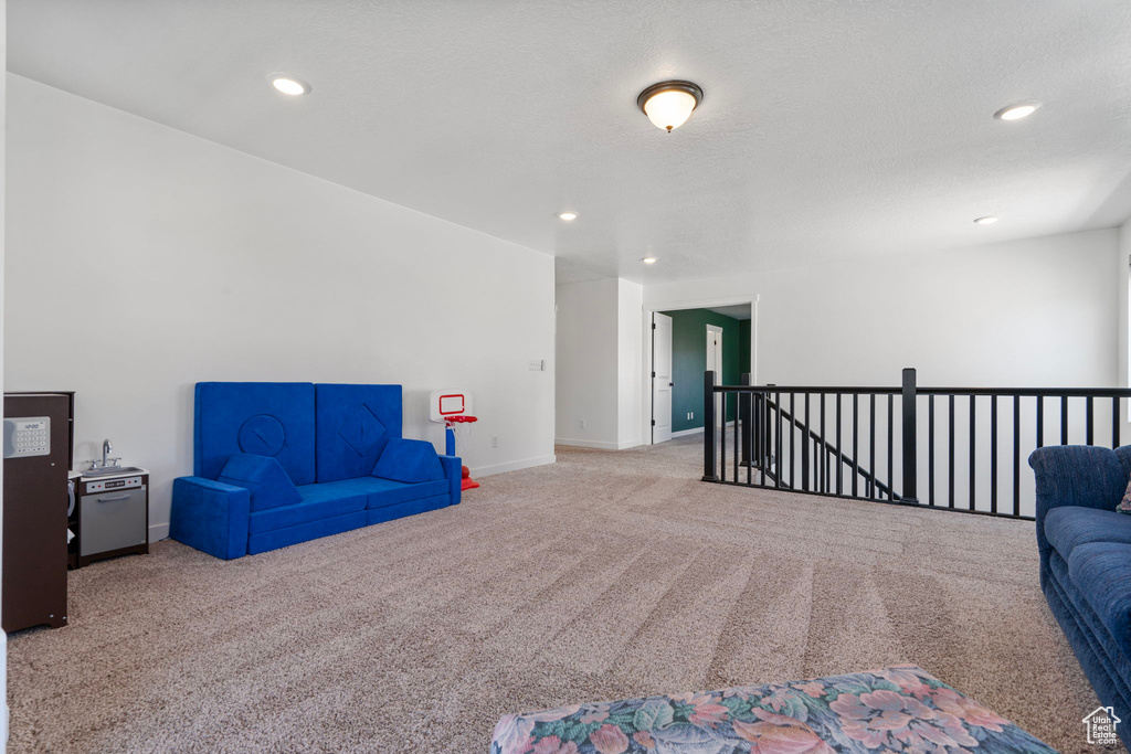 Sitting room with carpet, an upstairs landing, and recessed lighting