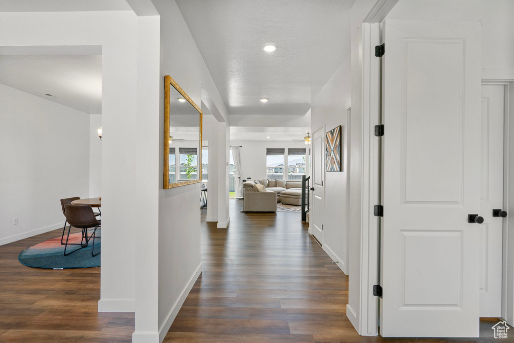 Corridor with dark wood-style flooring and recessed lighting