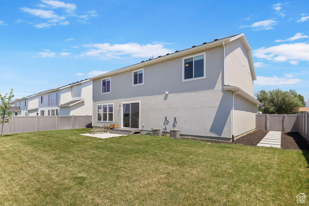 Back of house with a fenced backyard, stucco siding, a patio, and a gate