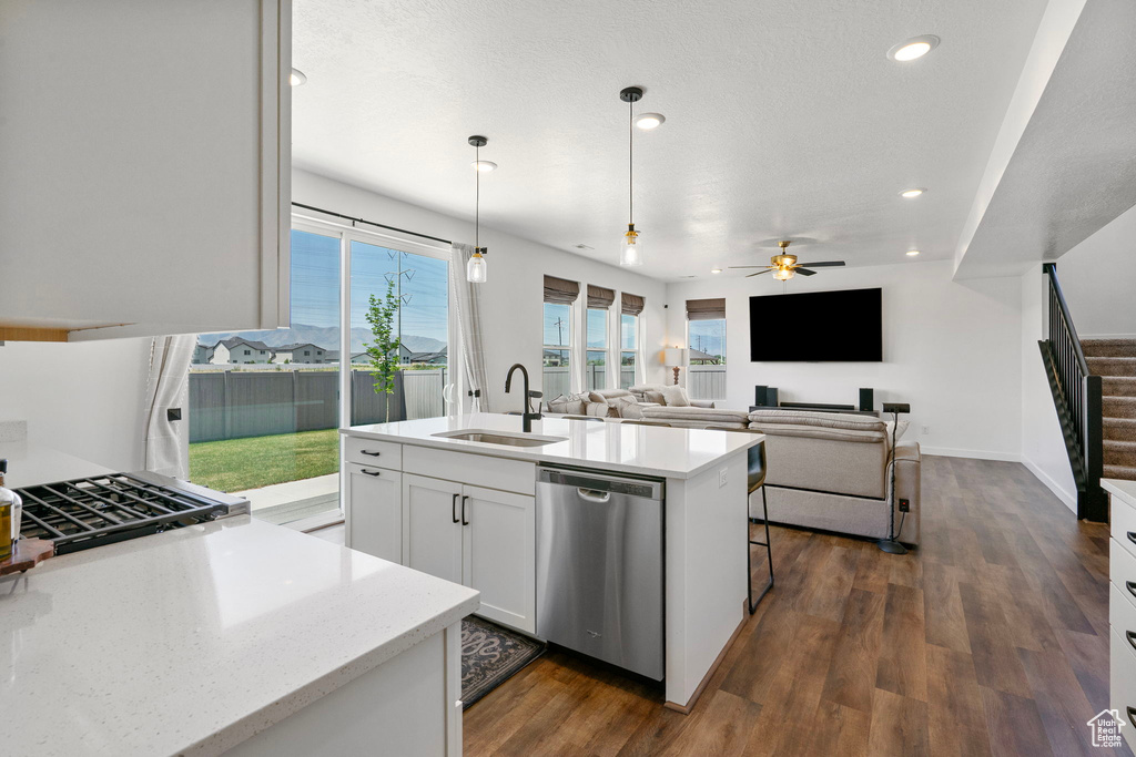 Kitchen with dishwasher, dark wood-style floors, recessed lighting, white cabinetry, and decorative light fixtures