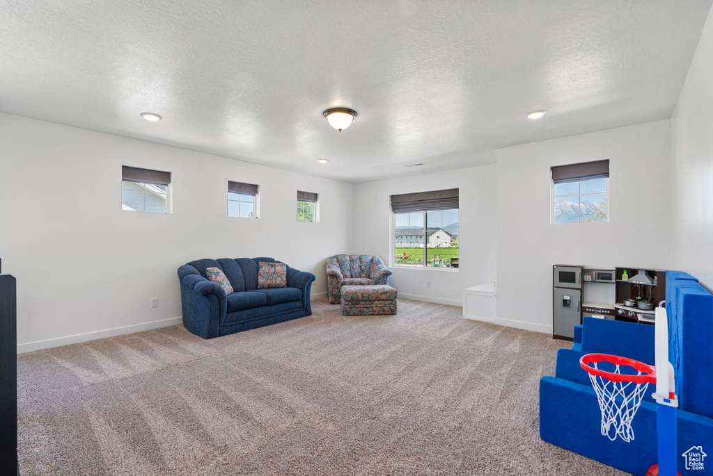 Playroom with carpet flooring, a textured ceiling, and recessed lighting