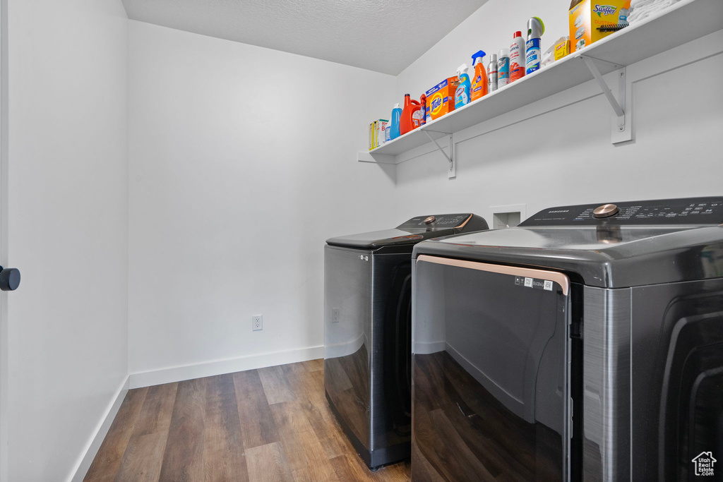 Washroom featuring independent washer and dryer and dark wood-type flooring