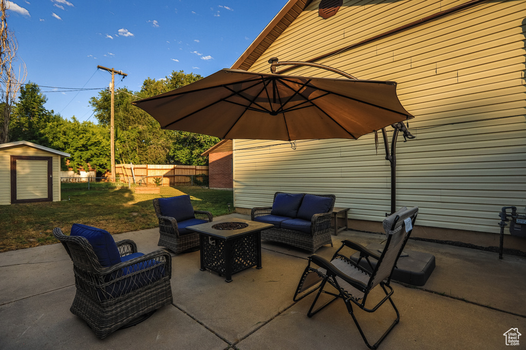 View of patio / terrace with a shed and an outdoor living space with a fire pit