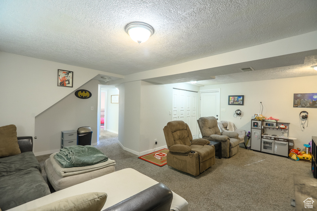 Carpeted living room with a textured ceiling