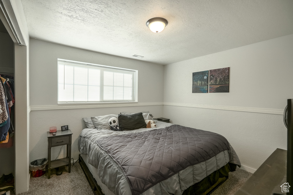 Carpeted bedroom with a textured ceiling
