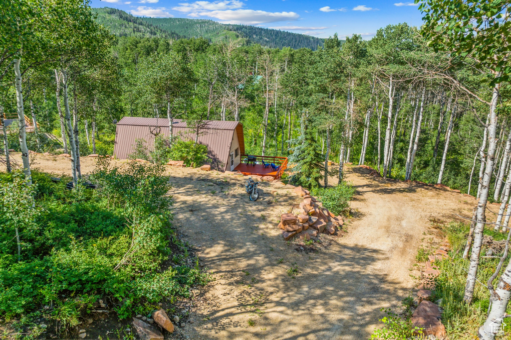 View of yard featuring a view of trees and a wooden deck