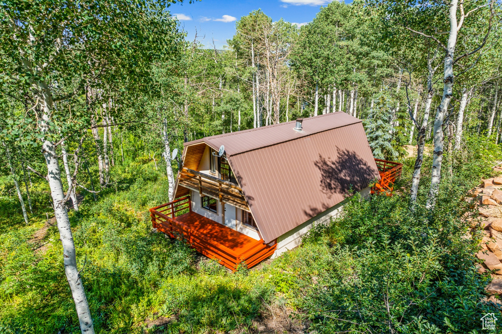 Aerial view of property and surrounding area with a heavily wooded area