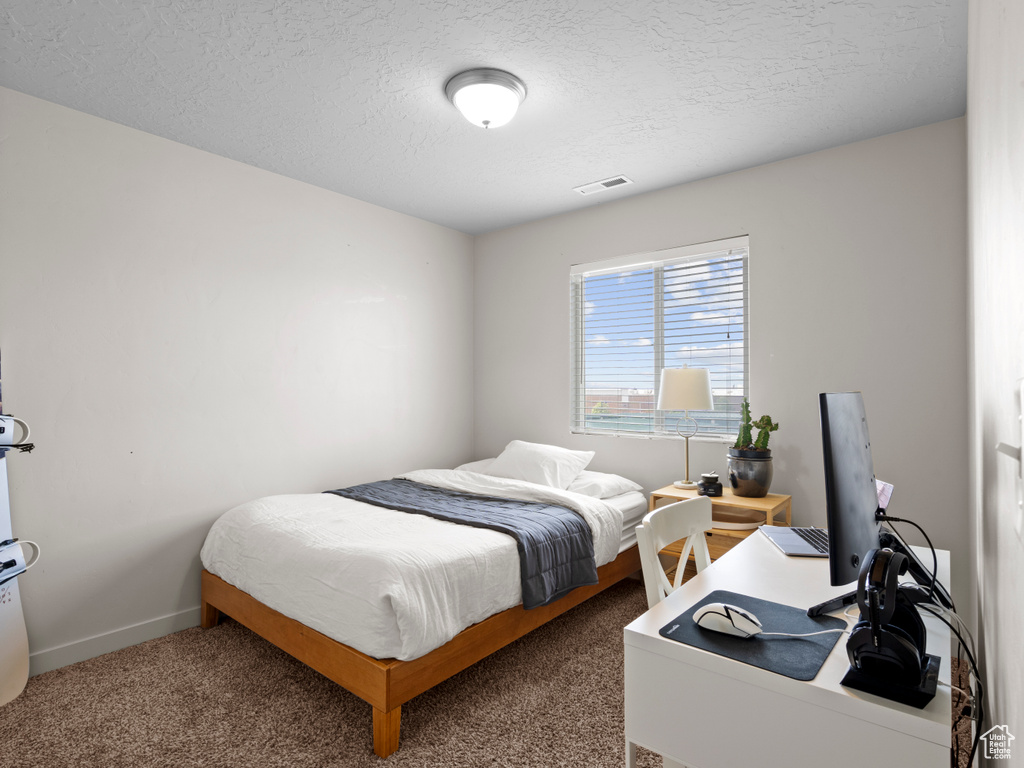 Bedroom with carpet flooring and a textured ceiling