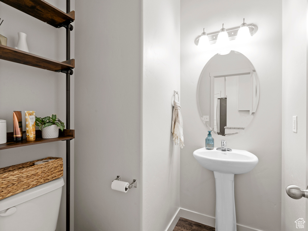 Bathroom with toilet and wood finished floors