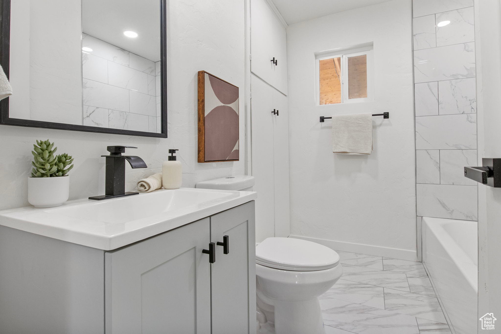 Full bath featuring marble finish floors, vanity, and shower / bathtub combination