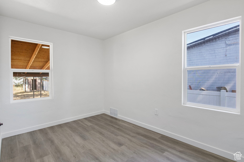Empty room with plenty of natural light and wood finished floors