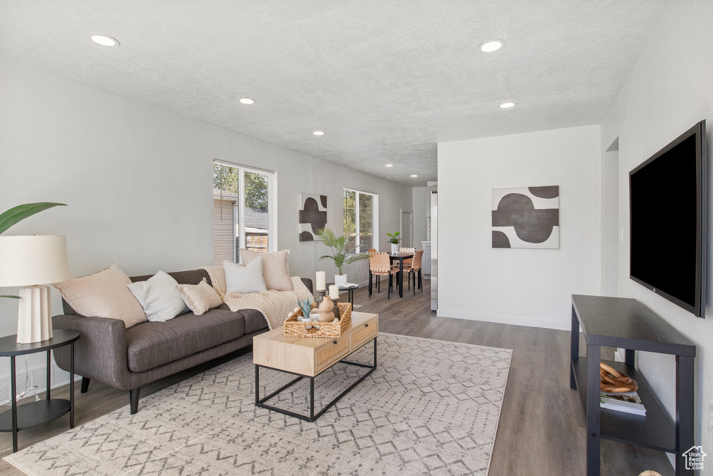Living area featuring wood finished floors, recessed lighting, and a textured ceiling